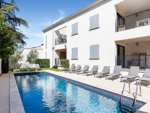 a swimming pool with chairs next to a building at Attractive Holiday Home in Malauc ne with Terrace in Malaucène