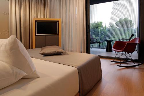 a bedroom with a bed and a television and a balcony at Lifestyle Hotel Vitar - Adults Only in Bol