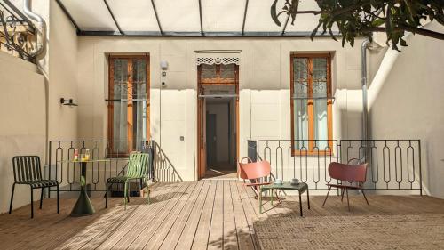 un groupe de chaises assises sur une terrasse en bois dans l'établissement Maison Juste, à Marseille