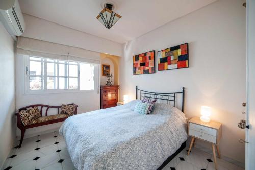 een slaapkamer met een bed, een stoel en een raam bij Luminoso apartamento céntrico 3 hab 2 baños in Sevilla