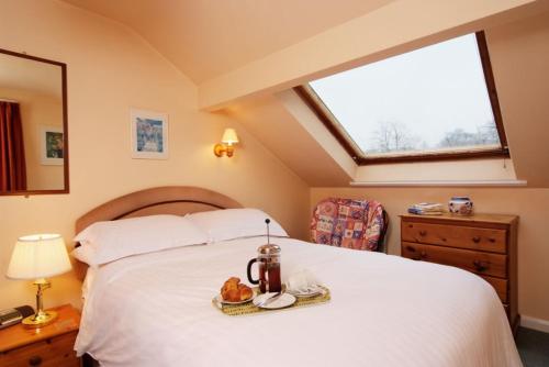 a bedroom with a large white bed with a window at Church Bank in Chapel Stile