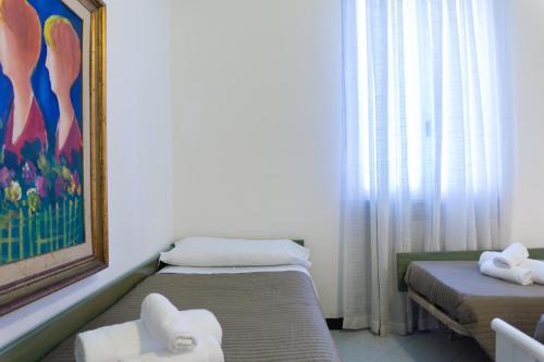 a small room with two beds and a painting at Esedra Hotel in Rimini