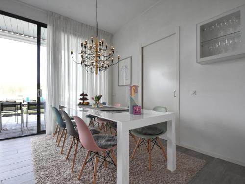 a dining room with a white table and chairs at Pleasant villa in Harderwijk with fenced garden in Zeewolde