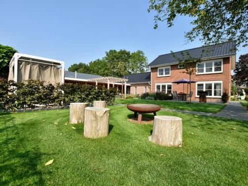 a park with a bench and three logs in the grass at Tranquil Group Retreat in Nature in Megchelen