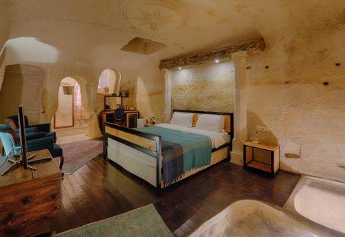 a bedroom with a bed and a tub in a room at Taru Cave Suites in Urgup