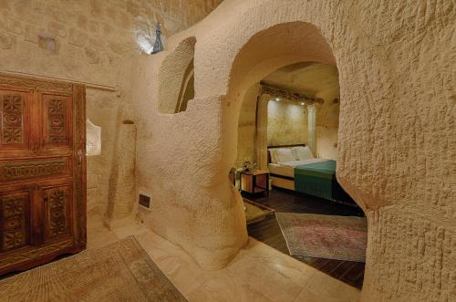 a bedroom with a bed in a stone wall at Taru Cave Suites in Urgup
