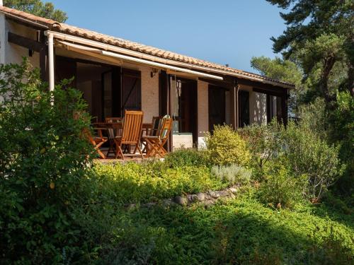 una casa con 2 sillas y una mesa en el porche en Hillside villa on private grounds with views, en Prades-sur-Vernazobre