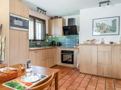 cocina con armarios de madera y mesa en Hillside villa on private grounds with views, en Prades-sur-Vernazobre