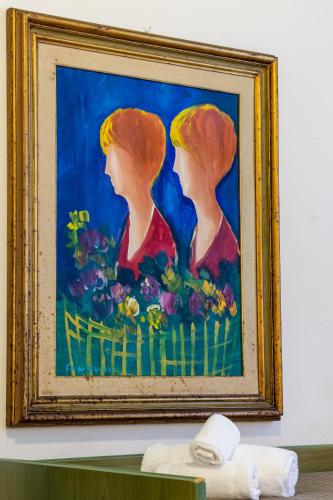 a painting of two women with flowers on a wall at Esedra Hotel in Rimini