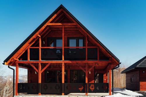 a log cabin with large windows on the side of it at Chata na Czarnym Groniu in Korbielów