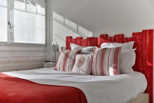 a bedroom with a red and white bed with pillows at La Villa Bel Ange Hotel in Saint-Philibert