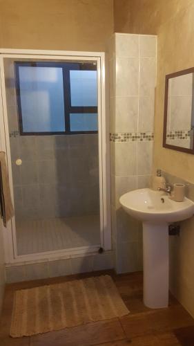 y baño con ducha, lavamanos y ducha. en Sabi falls accommodation en Sabie