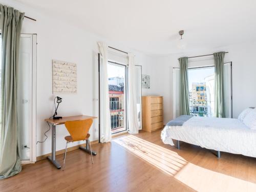 sypialnia z łóżkiem, biurkiem i oknami w obiekcie Rd2 aparcamiento incluido triana terraza privada w Sewilli