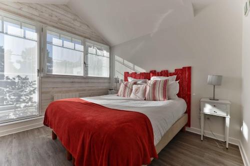 a bedroom with a large bed with a red blanket at La Villa Bel Ange Hotel in Saint-Philibert