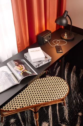 a desk with a chair and a desk with a lamp at Mama Shelter Paris La Défense in Puteaux