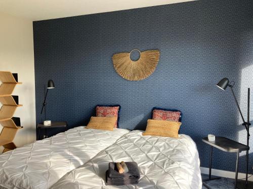 サン・ディエにあるLa Tuilerie Chambres d'Hôtesの青い壁のベッドルーム1室(大型ベッド1台付)