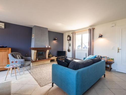 a living room with a blue couch and a fireplace at Quiet villa with private pool in Caunes-Minervois