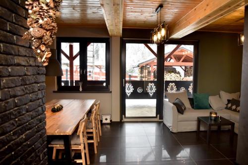 a living room with a wooden table and a couch at Chata na Czarnym Groniu in Korbielów