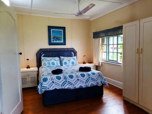a bedroom with a bed with a blue and white comforter at BillsBest Whaleback Cottage in Ramsgate