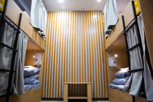a room with bunk beds and a wooden wall at People Hostel in Bishkek