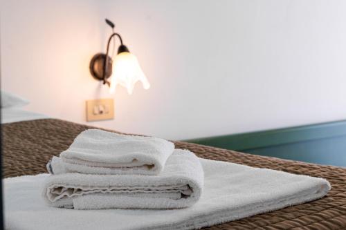 a stack of towels sitting on top of a bed at Esedra Hotel in Rimini