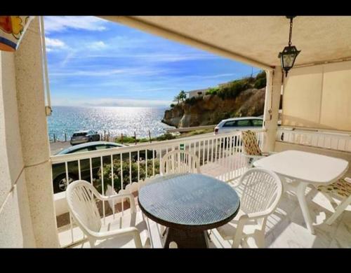 balcón con mesa, sillas y vistas al océano en Apartamento la isla, en San Juan de los Terreros