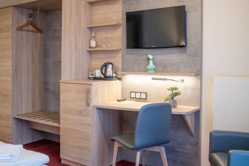 a room with a desk and a tv on a wall at Landhotel Stüer in Altenberge