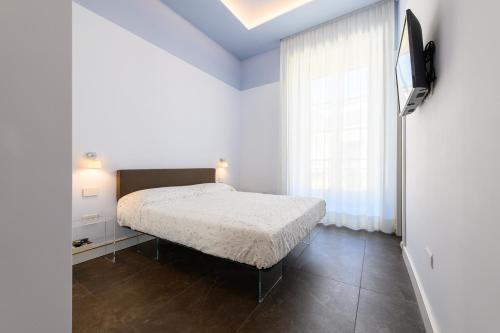 biała sypialnia z łóżkiem i oknem w obiekcie Corso Umberto 58 w mieście Neapol