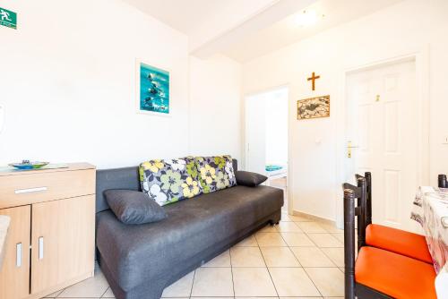 ein Wohnzimmer mit einem Sofa und einem Kreuz an der Wand in der Unterkunft Apartment Damir in Novalja