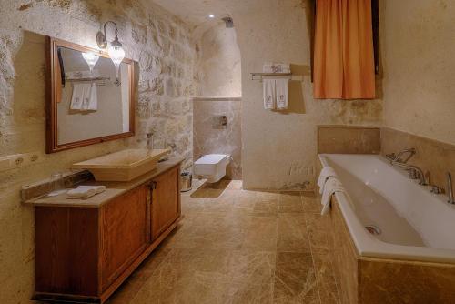 a bathroom with a tub and a sink and a toilet at Taru Cave Suites in Urgup