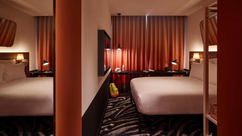 a hotel room with two beds and a desk at Mama Shelter Paris La Défense in Puteaux