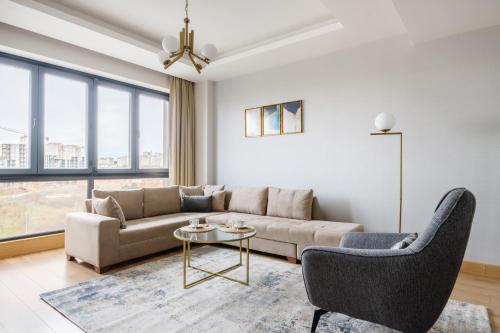 a living room with a couch and a table at Grand Residence by NewInn in Basaksehir