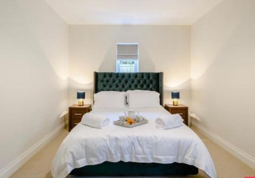 a bedroom with a bed with a tray of food on it at The Lodge in Coltishall