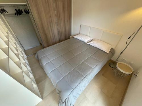 - un petit lit dans une petite chambre avec une lampe dans l'établissement Appartements Villa Rimbaud by Connexion, à Cannes