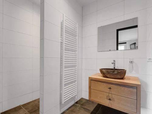 y baño con lavabo y espejo. en Appealing Holiday Home in De Koog Texel with Sauna, en Westermient