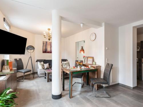 a dining room and living room with a table and chairs at Bright apartment in a district of Ilmenau in Stützerbach