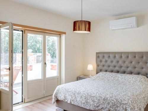 a bedroom with a bed and a sliding glass door at Wonderful villa in Ferreira do Zezere with private pool in Almogade