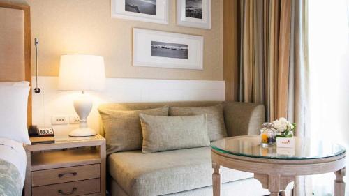a living room with a couch and a glass table at Amari Hua Hin in Hua Hin