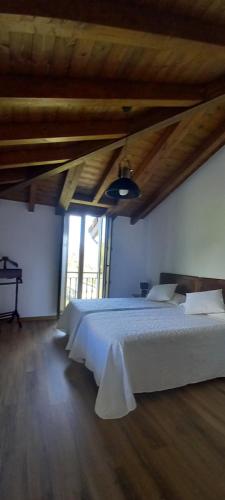 1 dormitorio con 1 cama blanca grande y techo de madera en Casa vacacional La Belluga, en Canales