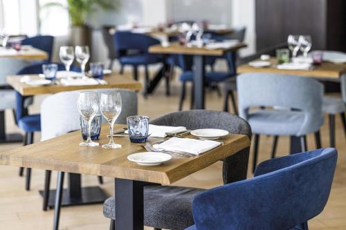 a table in a restaurant with wine glasses on it at Hôtel Serge Blanco - Relais Thalasso & Spa in Hendaye