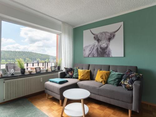 a living room with a couch and a picture of a cow at Tranquil Apartment in Marktleuthen near River and Forest in Marktleuthen