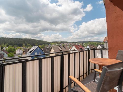 a balcony with a table and chairs and a view of a town at Tranquil Apartment in Marktleuthen near River and Forest in Marktleuthen