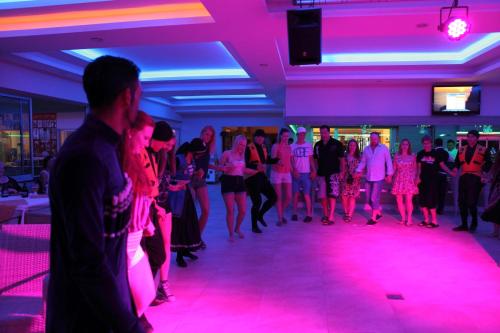 a group of people dancing in a room with pink lights at Catty Cats Garden Hotel in Side