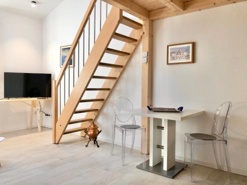 eine Treppe in einem Wohnzimmer mit einem Tisch und Stühlen in der Unterkunft Galeriestudio - Zentral in Gmund in Gmund am Tegernsee
