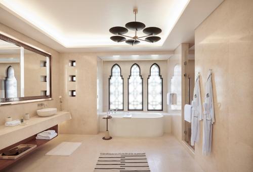 a bathroom with a tub and a sink and a mirror at Four Seasons Resort Sharm El Sheikh in Sharm El Sheikh