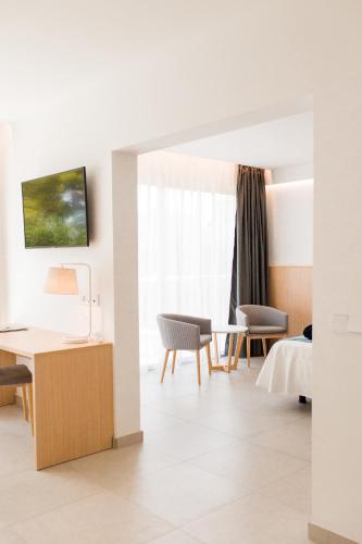 a room with a bed and a table and chairs at Gran Sagitario in Ciutadella
