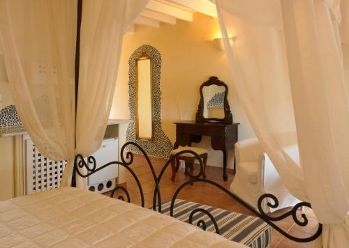 a bedroom with a bed and a table and mirror at Suites of the Gods Cave Spa Hotel in Megalochori