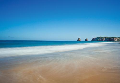 a view of the beach with rocks in the background at Hôtel Serge Blanco - Relais Thalasso & Spa in Hendaye