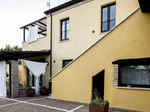 une maison jaune avec un rideau blanc sur son côté dans l'établissement Belvilla by OYO Giglio, à Ascoli Piceno