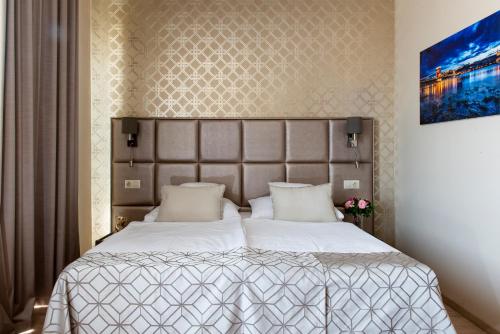 1 dormitorio con 1 cama grande con sábanas blancas en Vánkos & Eszcájg, en Újhartyán